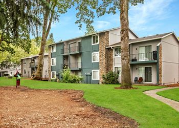 Patios and decks at Cornell Woods apartments overlooking green space with trees